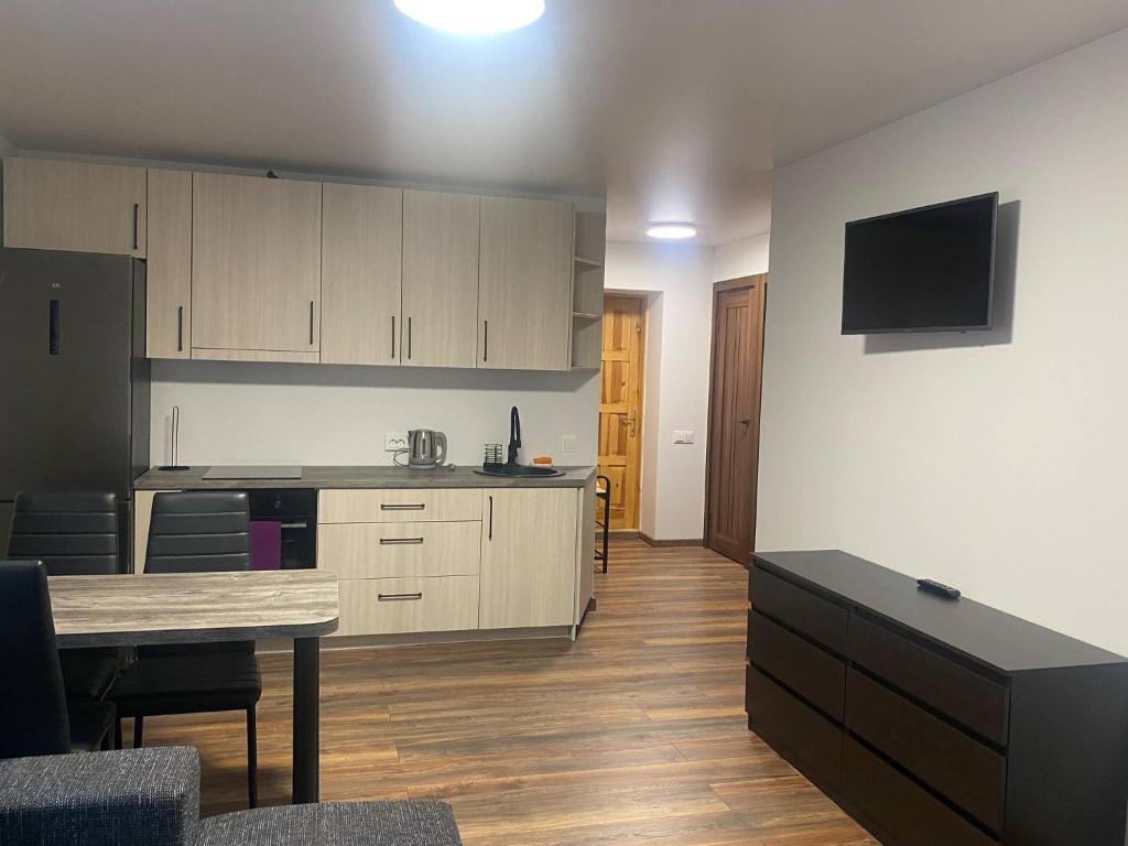 a kitchen with white cabinets and a table in a room at Butas Čiurlionio gatvėje in Pakopi