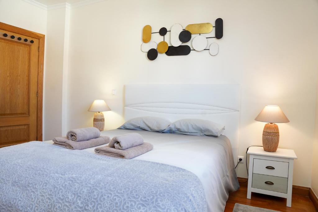 een slaapkamer met een bed met handdoeken erop bij Rosária Flat in Santa Cruz