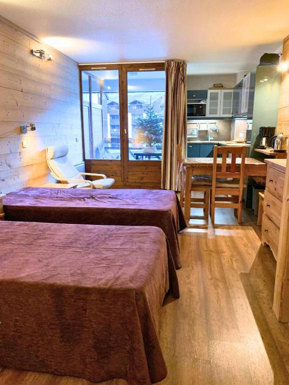 a hotel room with two beds and a kitchen at Studio charmant et confortable Brides Les Bains in Brides-les-Bains