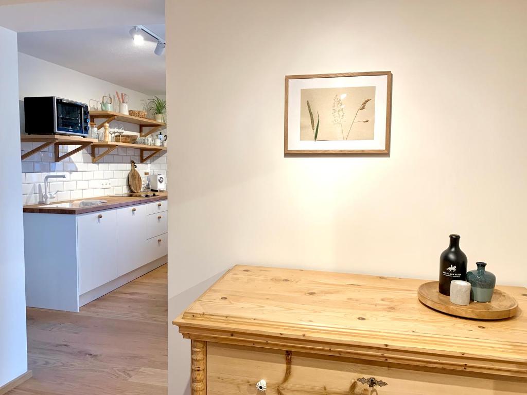 a kitchen with a table and a picture on the wall at VOM REITER, Ferienwohnung am Bauernhof mit Bergblick und privater Infrarotkabine, Inklusive Sommercard in Schladming