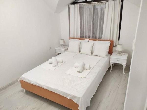 a bedroom with a large bed with white sheets and white pillows at Апартамент Сънсет Созопол in Sozopol