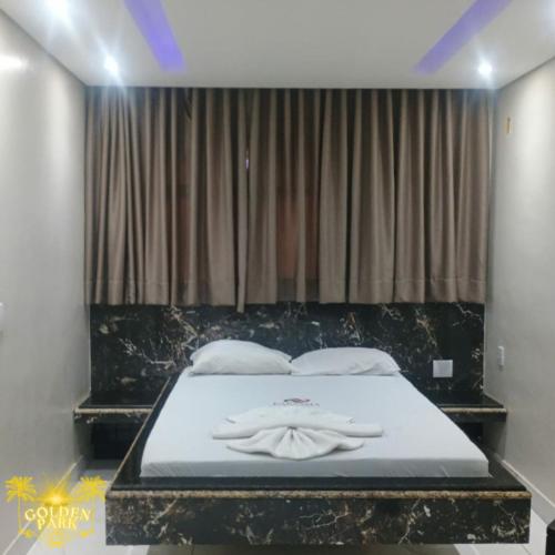 una camera da letto con un letto con lenzuola e cuscini bianchi di Golden Park Hotel II a Brasilia
