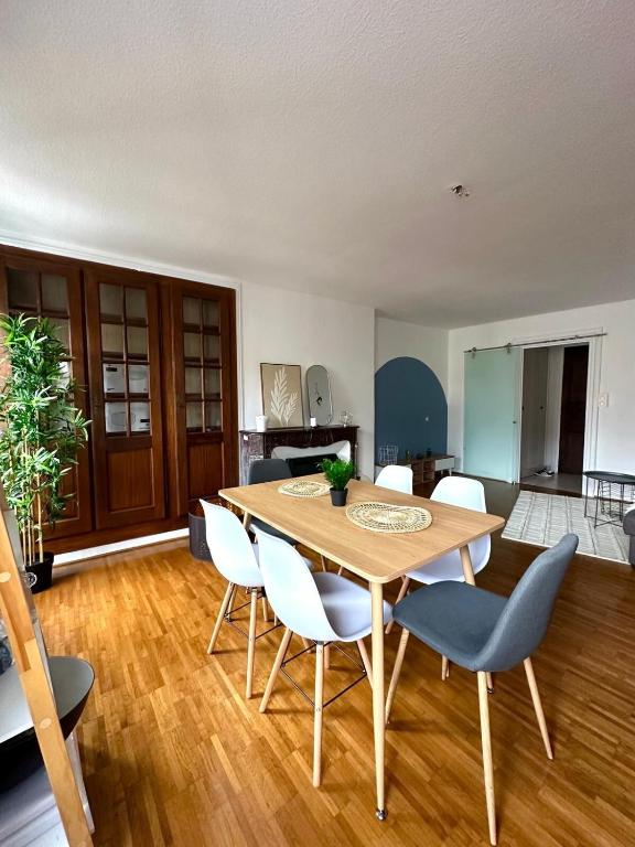 une salle à manger avec une table et des chaises en bois dans l'établissement Spacieux T3 avec vue imprenable, au Puy-en-Velay