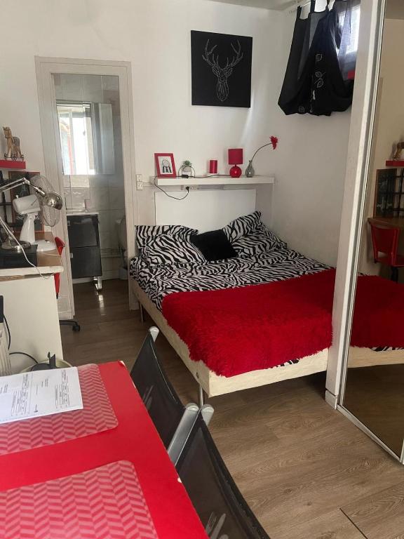 une chambre avec un lit avec une couverture rouge dans l'établissement Petit Studio en plein centre, à Clermont-Ferrand