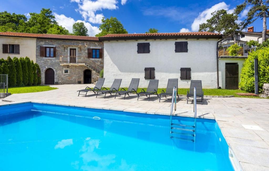 a villa with a swimming pool and chairs at Casa Antica - Storia Verde Opatija in Veprinac