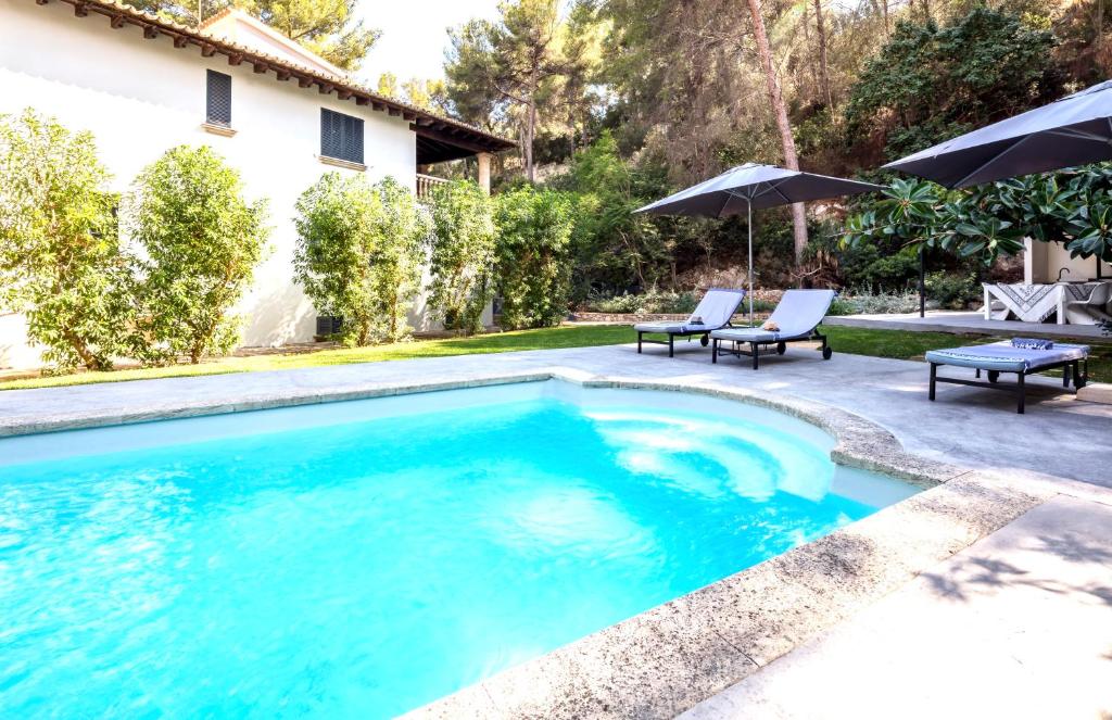 a swimming pool with blue water in a yard at Villa Margarita in Palma de Mallorca