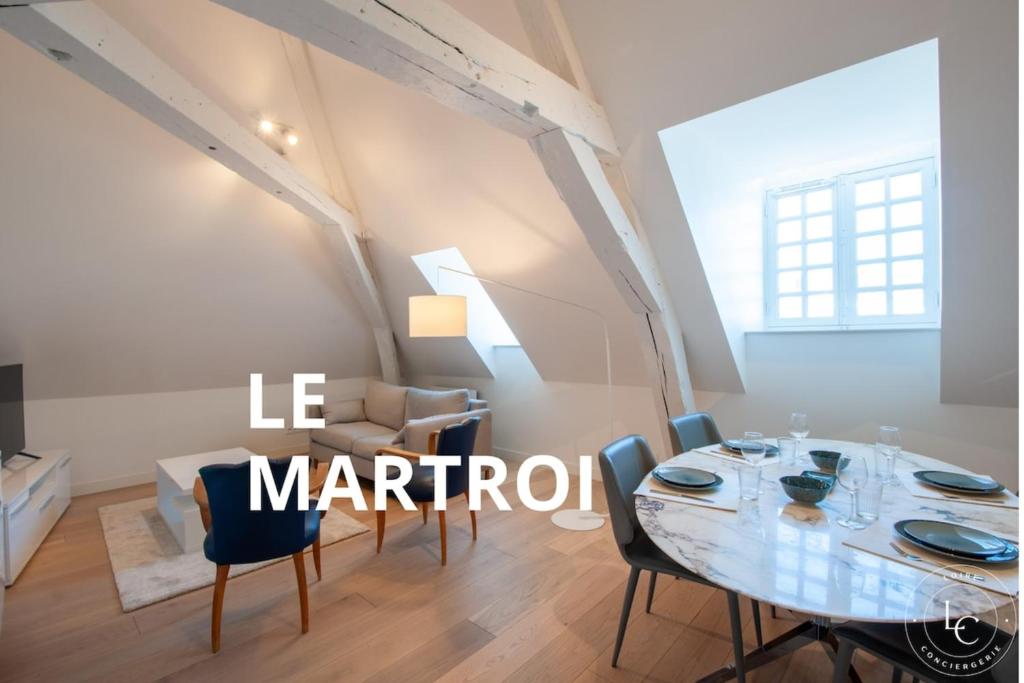 une salle à manger blanche avec une table et des chaises dans l'établissement Le Martroi - Hypercentre avec vue - 55m 1 chambre, à Orléans