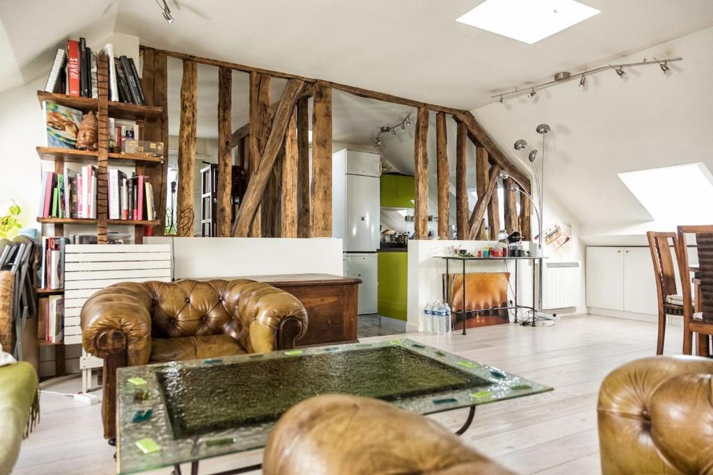 un salon avec des meubles en cuir et une table dans l'établissement Coeur de Paris sous les toits, à Paris
