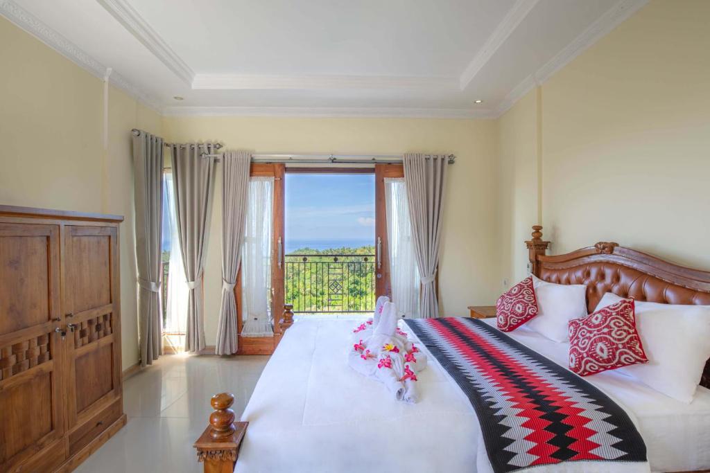 una camera da letto con un letto grande con una grande finestra di Atuh Galaxy Cottage a Nusa Penida