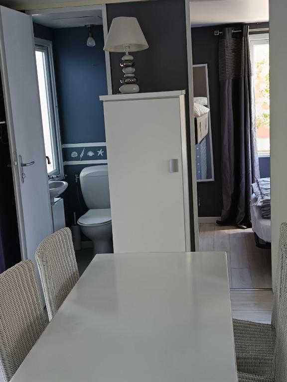 a dining room with a white table and chairs at Camping DEL MAR in Argelès-sur-Mer
