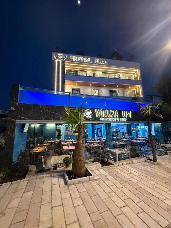 a view of a building with a palm tree in front at Ilio Boutique Hotel in Ksamil