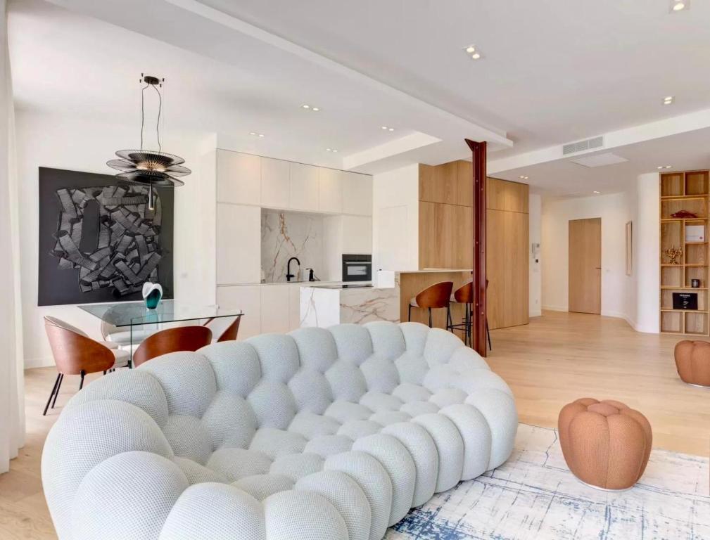 - un grand canapé blanc dans un salon avec une cuisine dans l'établissement Luxury Apt Cannes Croisette sea view with terrasse, à Cannes