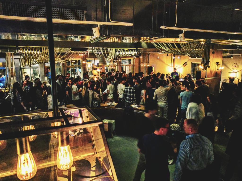 a crowd of people in a room with a crowd of people at The Post Hostel Jerusalem in Jerusalem