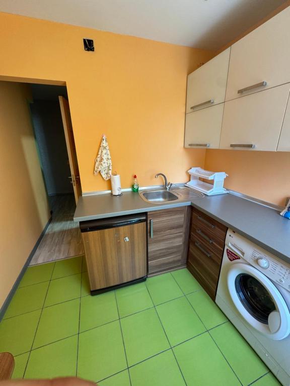 a kitchen with a sink and a washing machine at Aeroport apartament in Chişinău