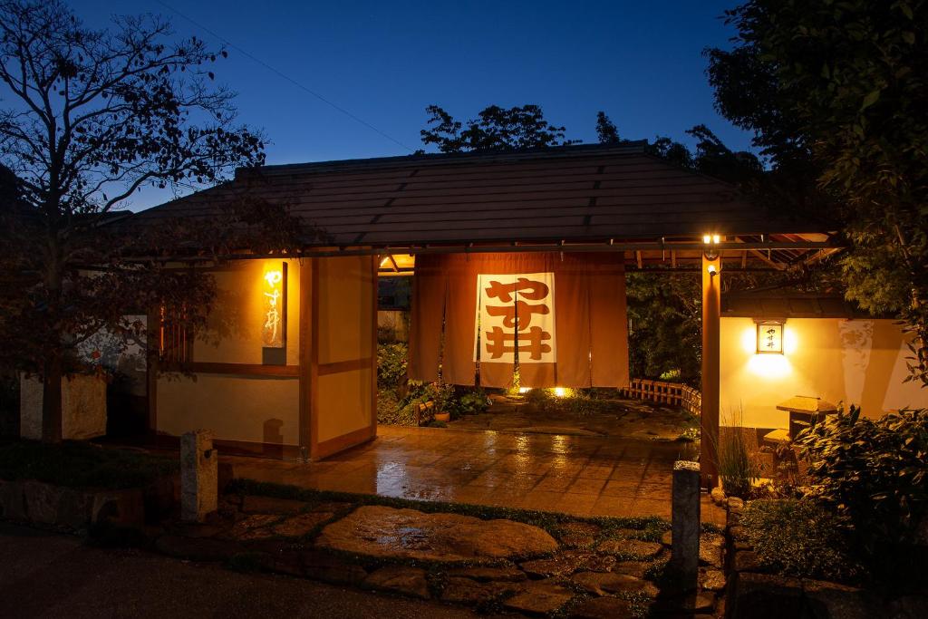 a small building with a sign on it at night at Ryoutei Ryokan Yasui in Hikone