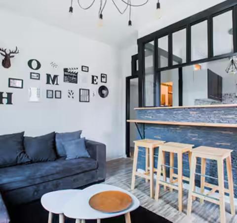 - un salon avec un canapé et deux tabourets dans l'établissement Charmant cocon tout équipé, à Clermont-Ferrand