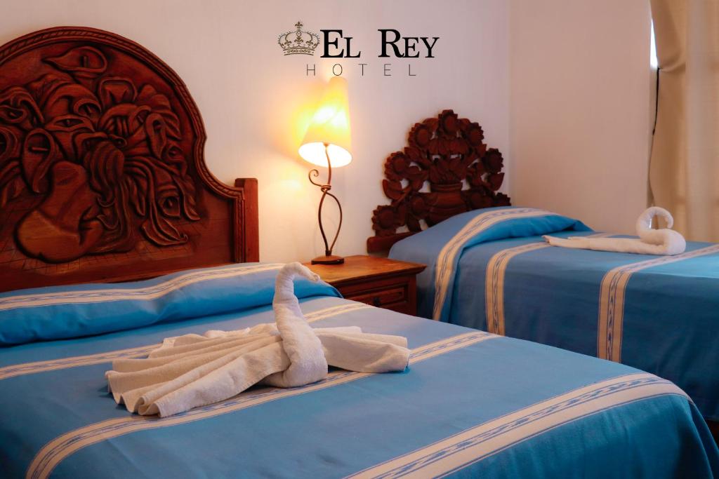 a hotel room with two beds with towels on them at El Rey in Taxco de Alarcón
