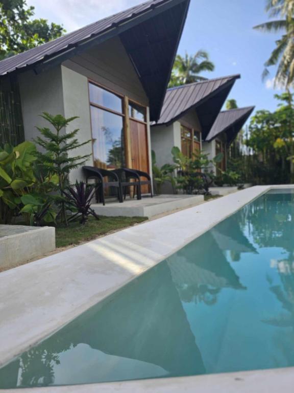a house with a swimming pool in front of a house at WADI Hut Siargao in General Luna