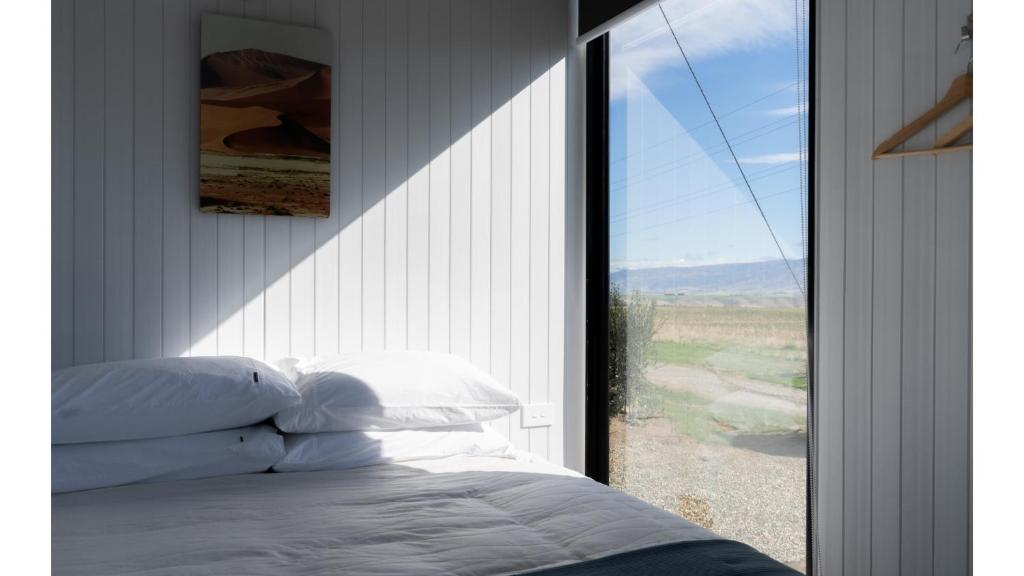 Postel nebo postele na pokoji v ubytování Ruffell Ranch Cabin by Tiny Away