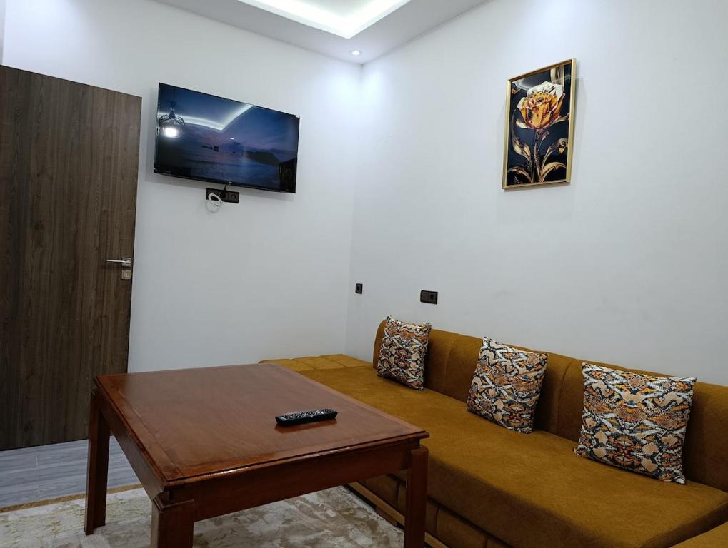 a living room with a couch and a table at La maison bleu in Oulad Akkou