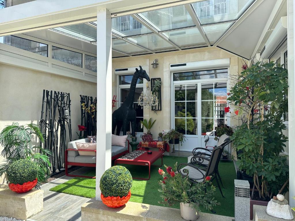 a conservatory with a giraffe statue on a patio at Maison de ville in Saint-Jean-dʼAngély