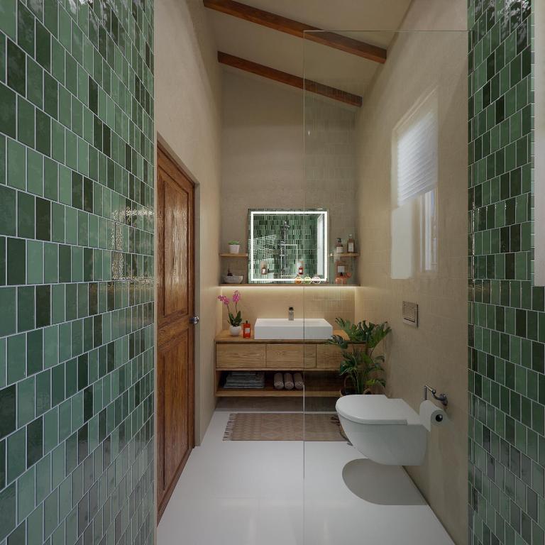 un bagno con un water, un lavandino e uno specchio di C Roque Beach Resort a Colva