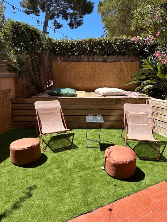 deux chaises et un lit dans une cour avec de l'herbe dans l'établissement Studio 3 mn de la mer -Proche Sablettes, à La Seyne-sur-Mer