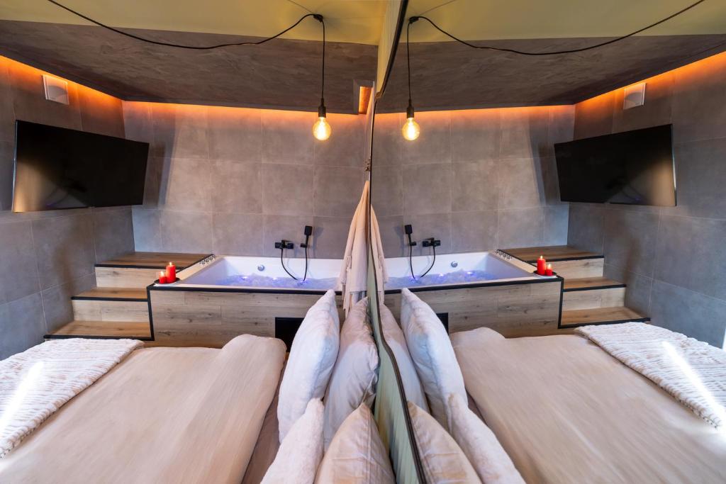 a bedroom with two beds and a bath tub at Ecrin des Alpes, Jacuzzi, Netflix, Ambiance chalet in Saint-Étienne