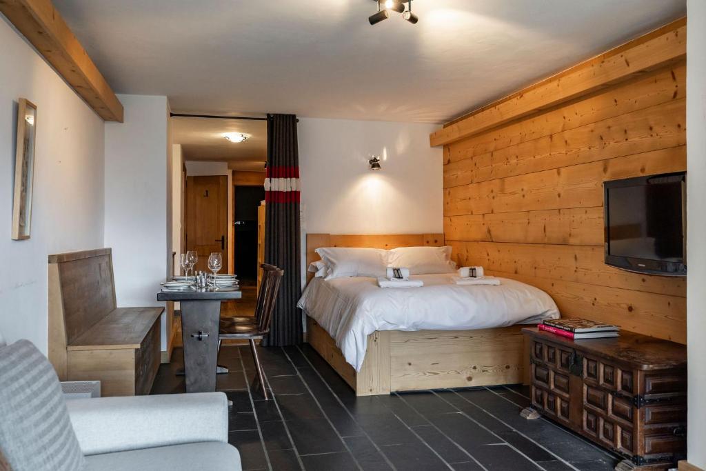 a bedroom with a bed with a wooden wall at La Ruinette-spacious studio in Verbier centre in Verbier