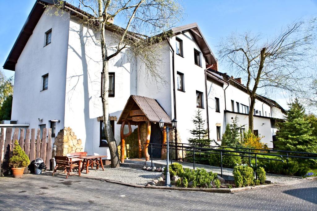 un gran edificio blanco con una mesa de picnic delante de él en Hotel Stawisko Klaudyn, en Klaudyn