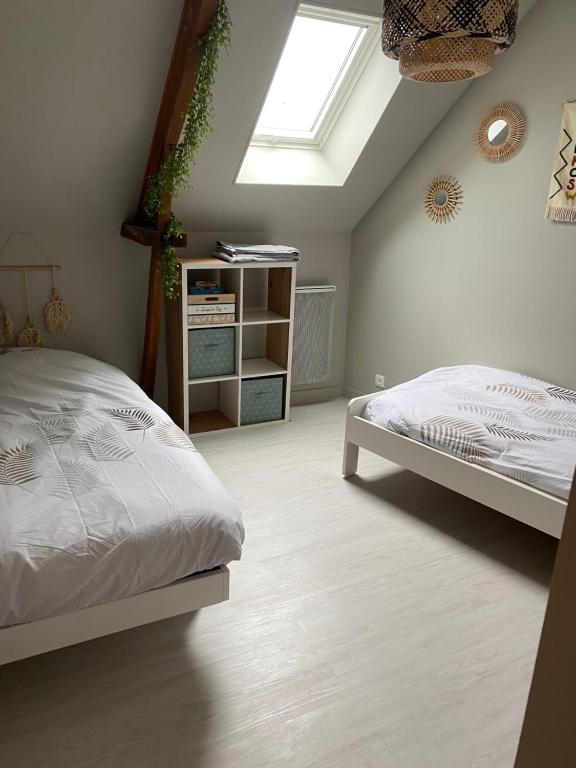 a bedroom with a bed and a skylight at Aux Petits Bonheurs in Grandcamp-Maisy
