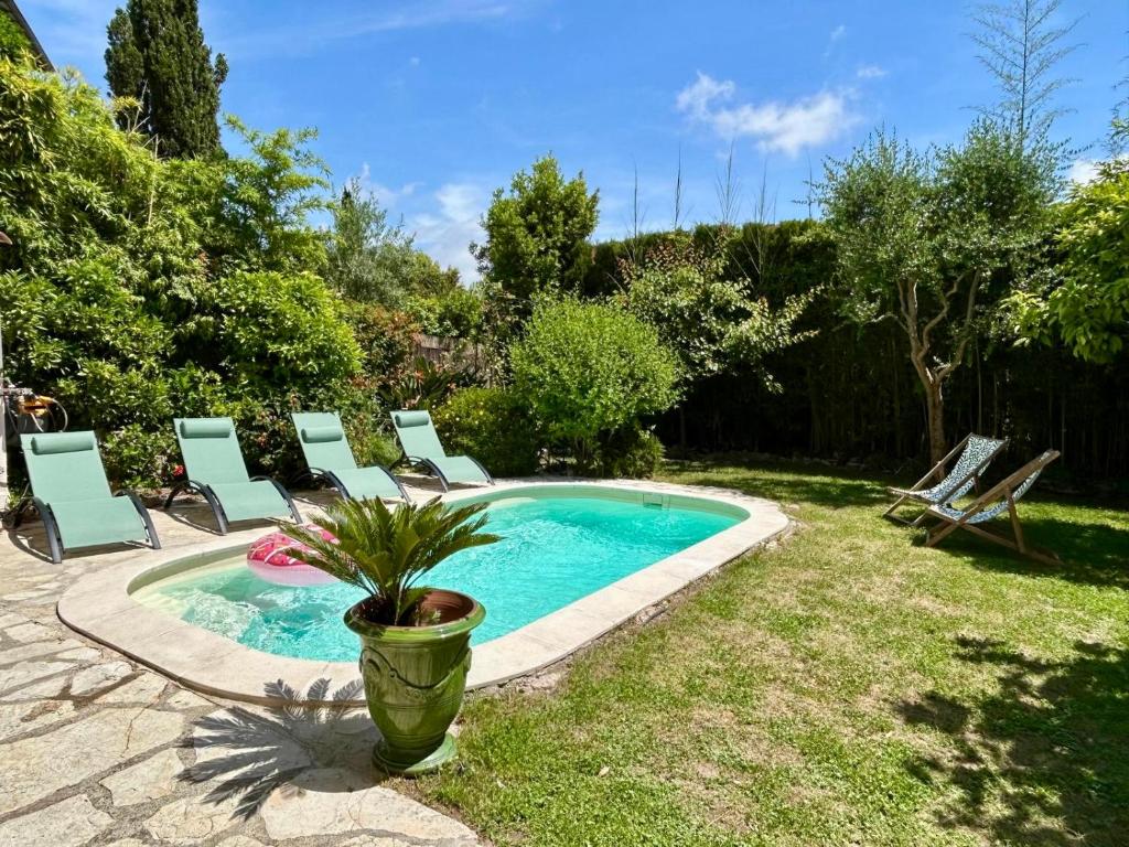 une piscine avec des chaises et une plante dans une cour dans l'établissement C8 - Lovely House Cannes 4 BDR - Pool, AC, Garage & Wifi, à Cannes