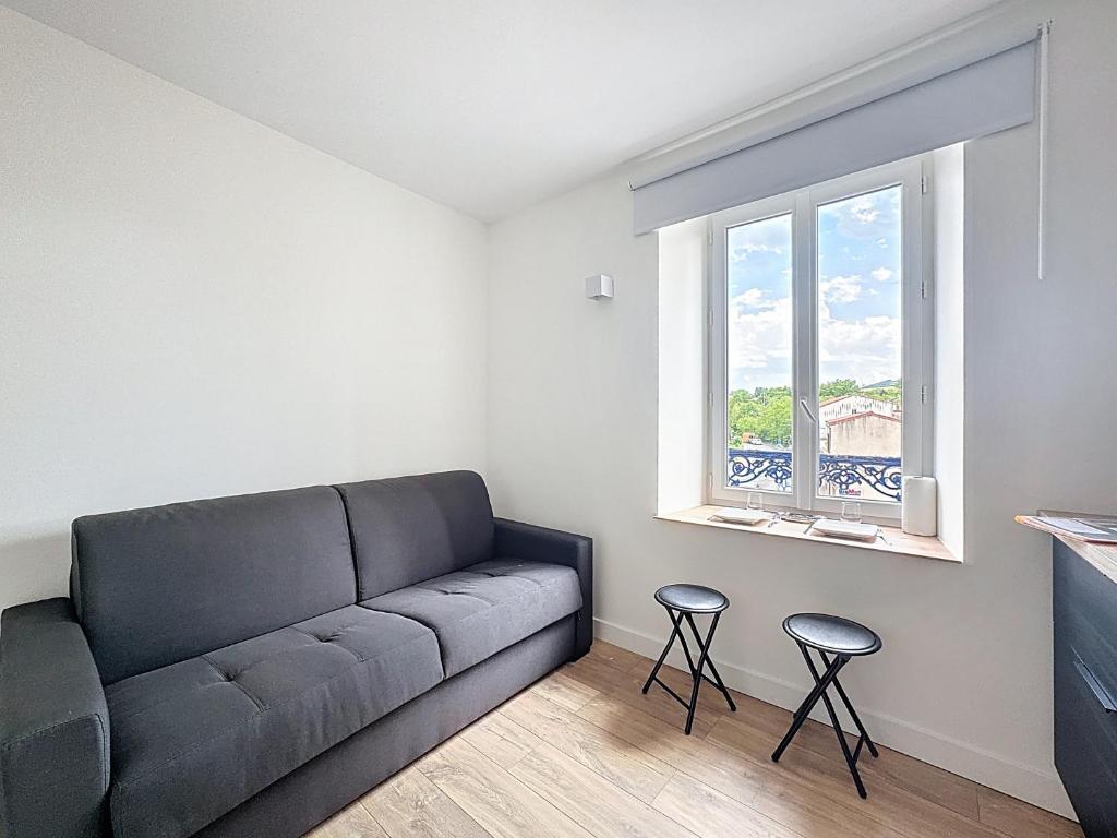 a living room with a couch and two stools at Les chambres de Coudes N4,clim, proche A75 in Coudes