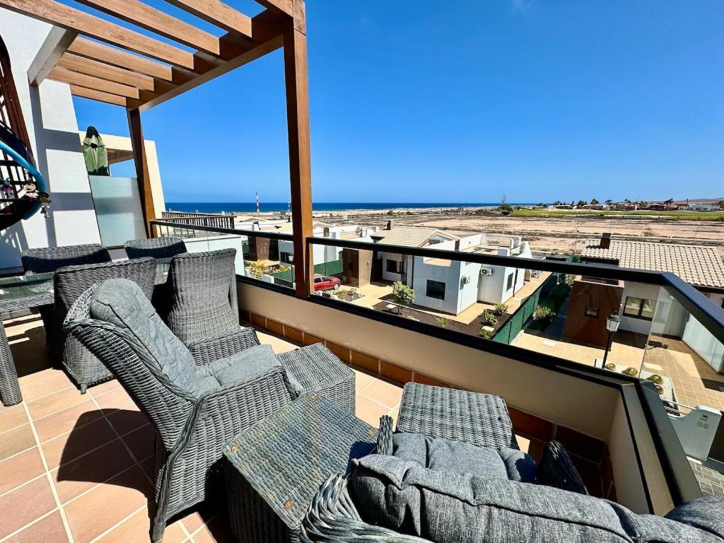 a balcony with chairs and a view of the beach at Casa Lily in Antigua