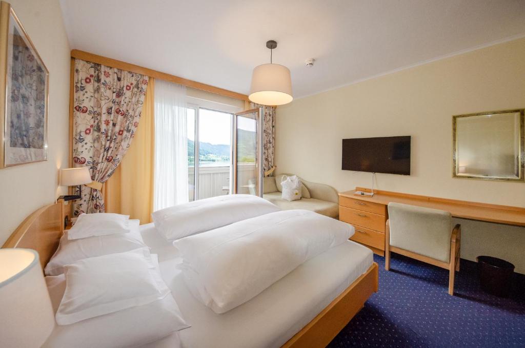 Postel nebo postele na pokoji v ubytování Hotel Ossiacher See