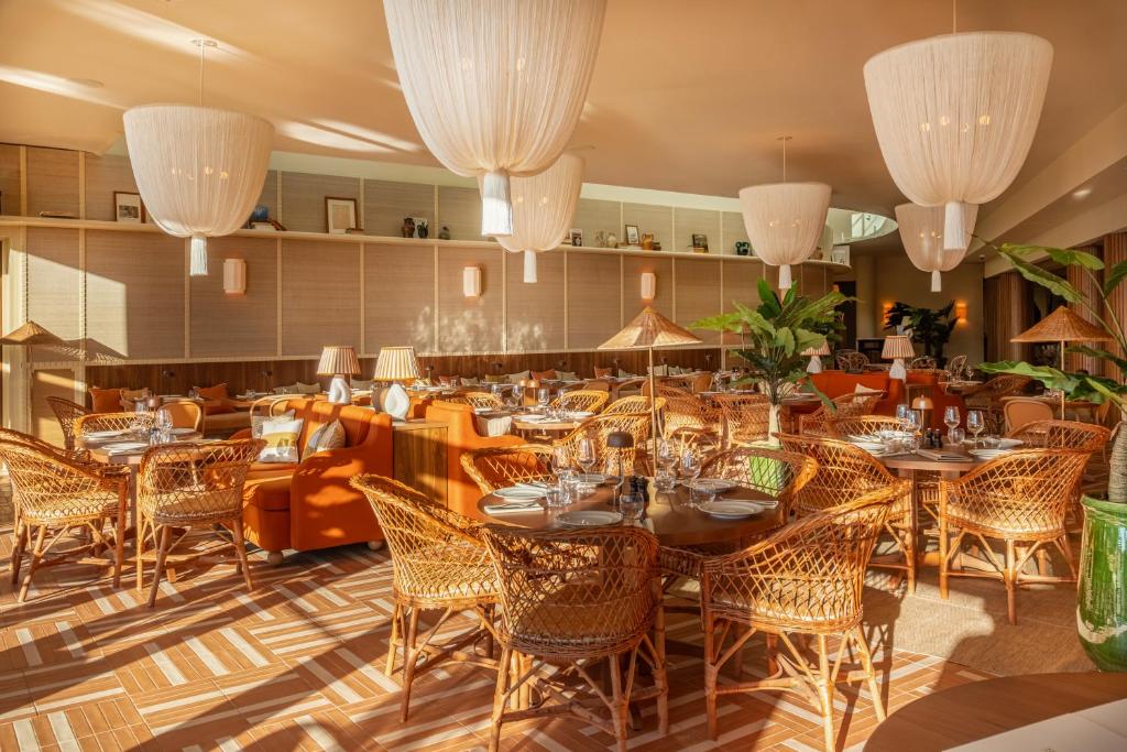 a restaurant with tables and chairs and chandeliers at Hôtel Villa M Marseille in Marseille