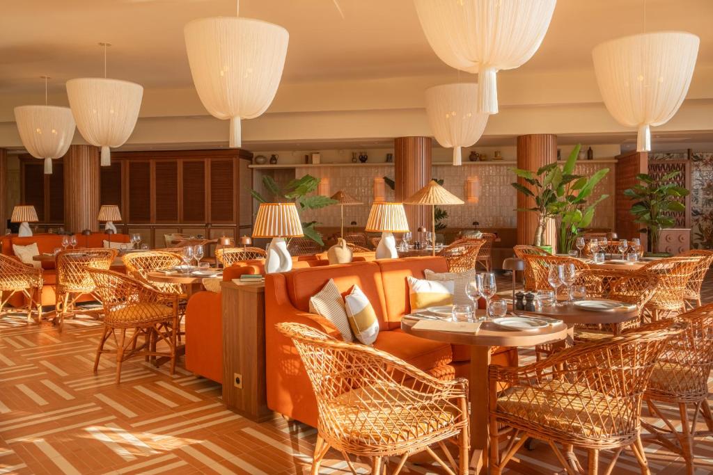 a restaurant with tables and chairs and chandeliers at Hôtel Villa M Marseille in Marseille