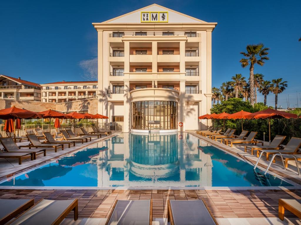 a hotel with a swimming pool and chairs at Hôtel Villa M Marseille in Marseille