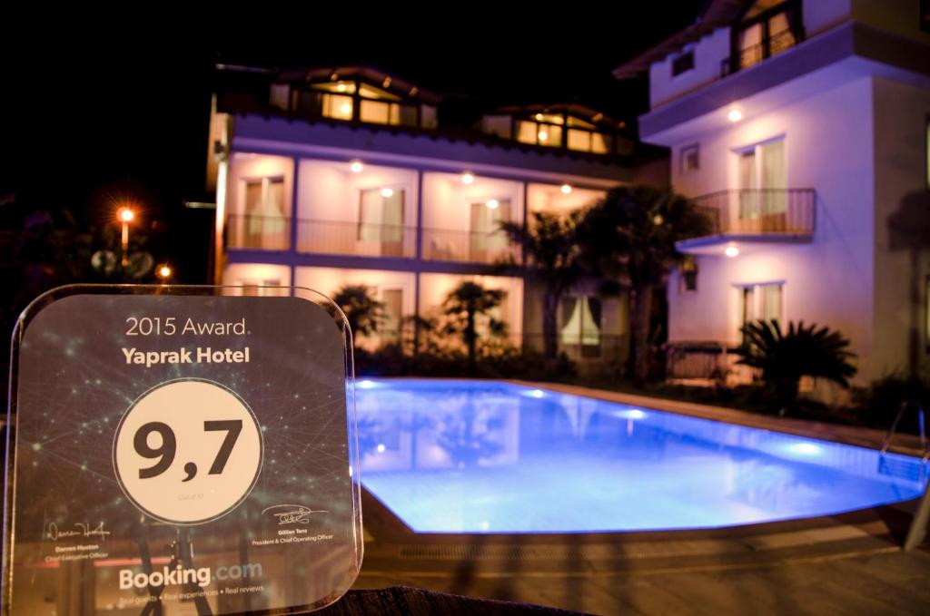 a swimming pool in front of a house at night at Yaprak Hotel in Dalyan