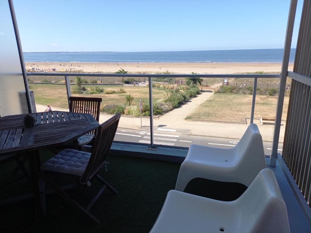 a balcony with a table and chairs and a view of the beach at Les tamaris in Saint-Brevin-les-Pins