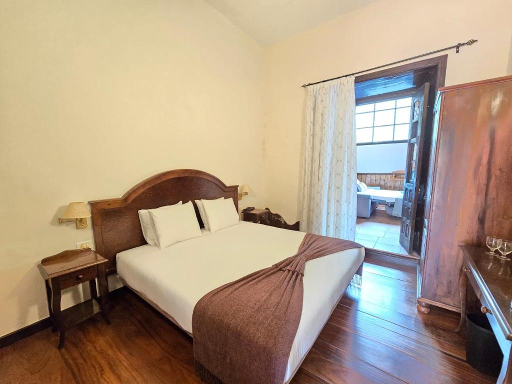 a bedroom with a bed and a large window at Tamahuche Hotel Rural in Vallehermoso