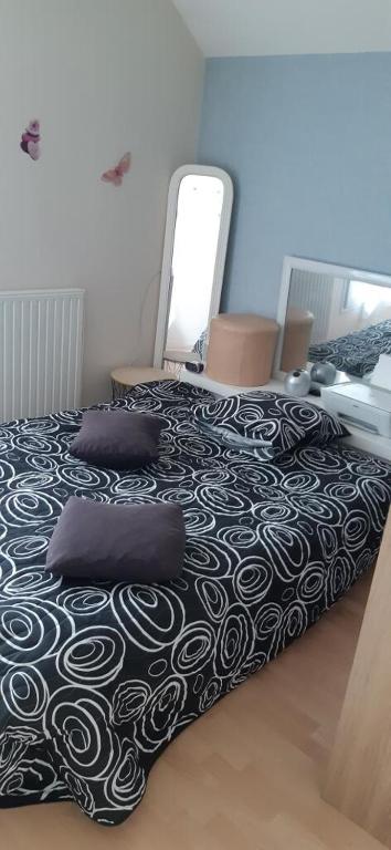 a bedroom with a black and white bed with two pillows at Maison rue Sonia Delaunay LE MANS in Le Mans