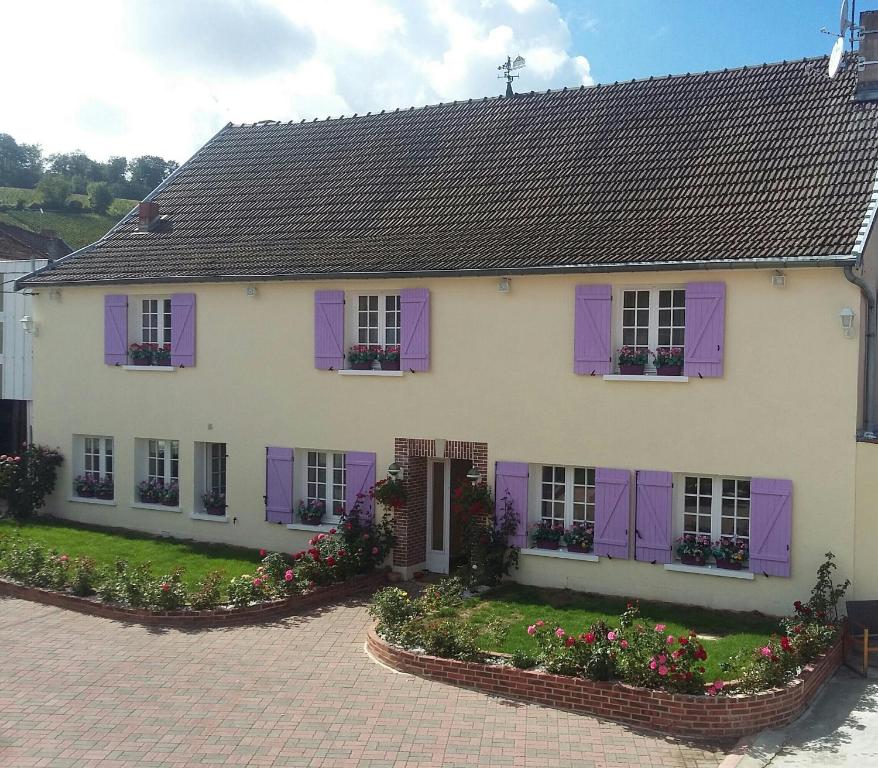 a white house with purple shutters and flowers at Chavot Bellevue in Chavot-Courcourt