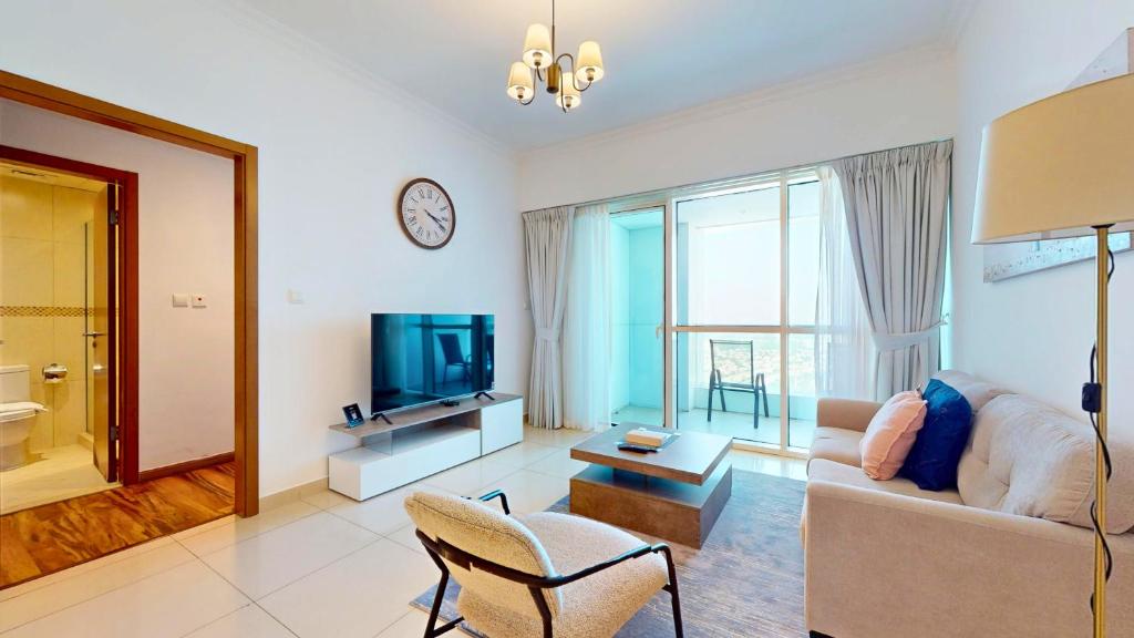 a living room with a couch and a tv at Modern 1BR in Saba Tower 2 - Prime JLT Location in Dubai