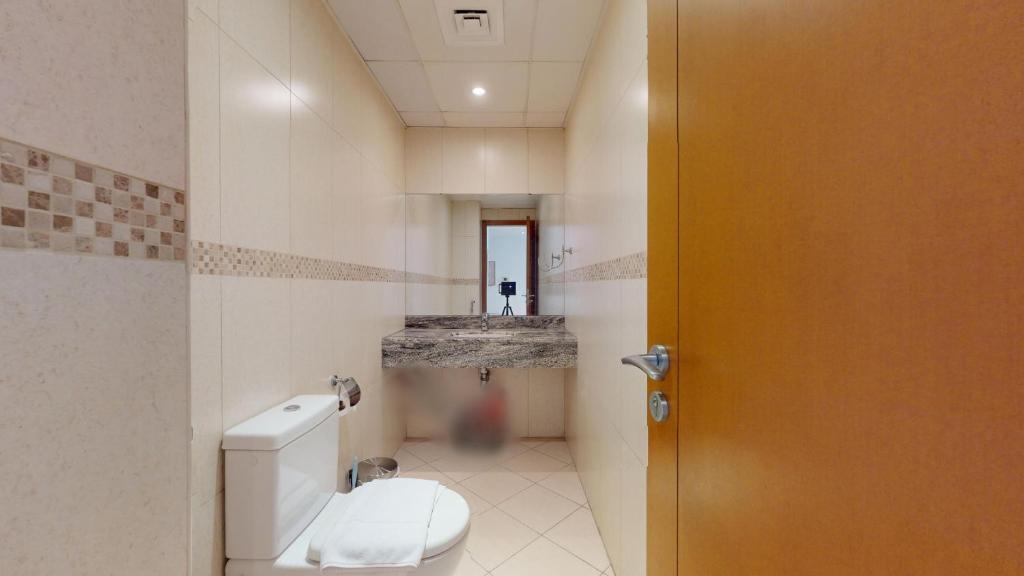 a bathroom with a toilet and a sink at Modern 1BR in Saba Tower 2 - Prime JLT Location in Dubai