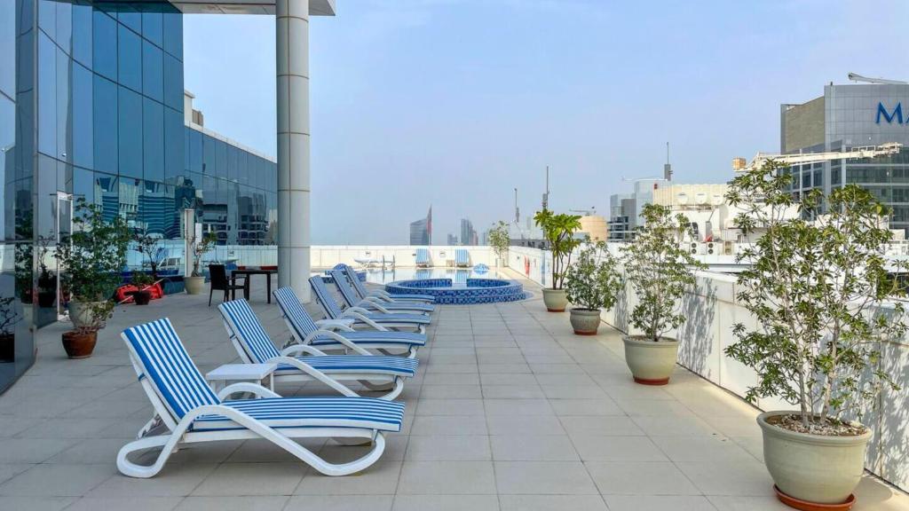 a row of lounge chairs sitting on a balcony at Modern 1BR in Saba Tower 2 - Prime JLT Location in Dubai