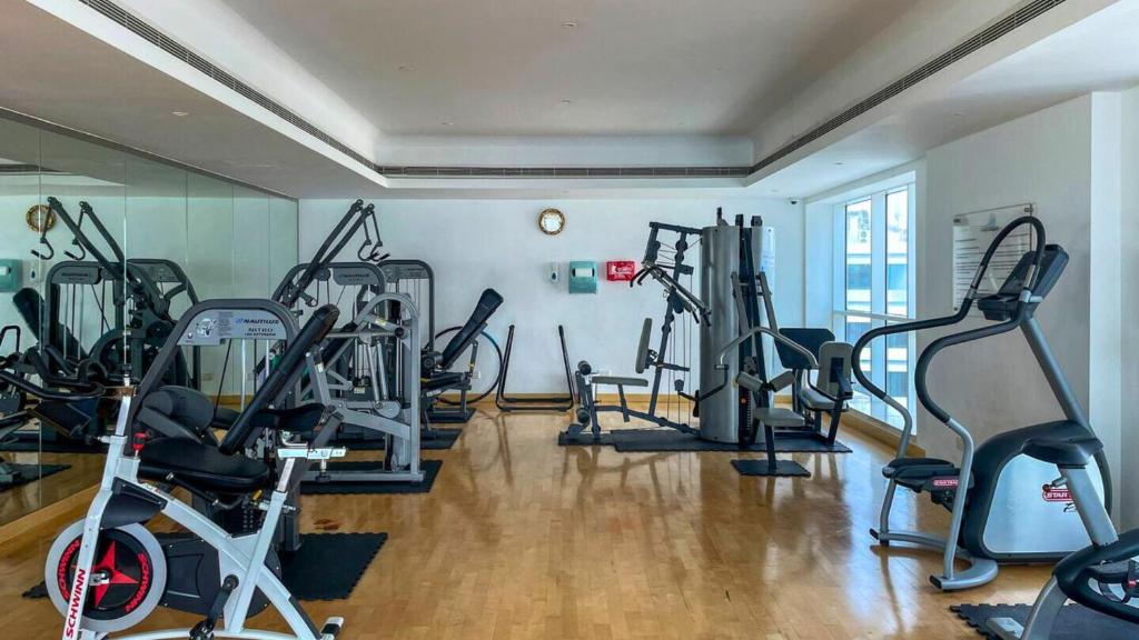 a gym with several tread machines in a room at Modern 1BR in Saba Tower 2 - Prime JLT Location in Dubai
