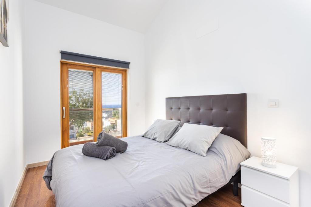 a bed with two pillows on it in a bedroom at Casa Malo Garden and sea view townhouse in La Jaca