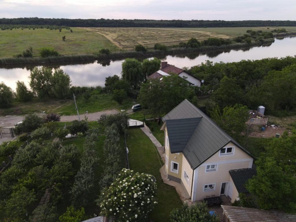 une vue aérienne d'une maison au bord d'une rivière dans l'établissement Family home, near therme/airport/ lake, Balotesti, à Căciulaţi