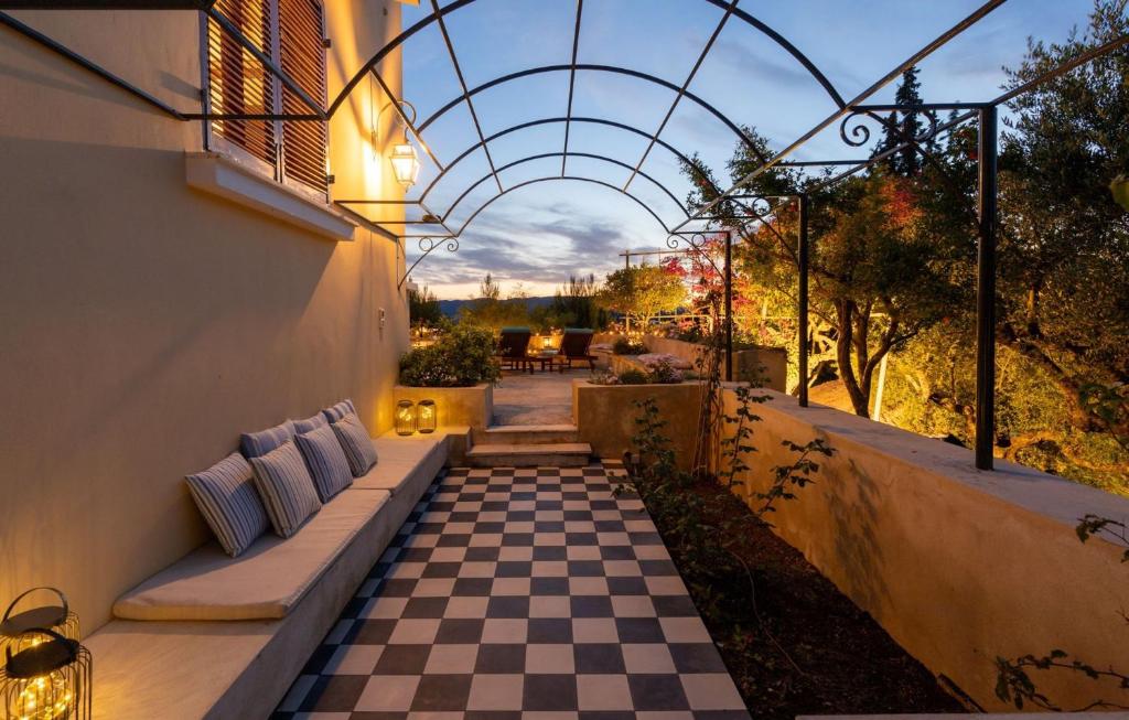 a patio with a checkered floor and a pergola at La Belle Villa - Family Retreat Magnificent View in Akrotiri